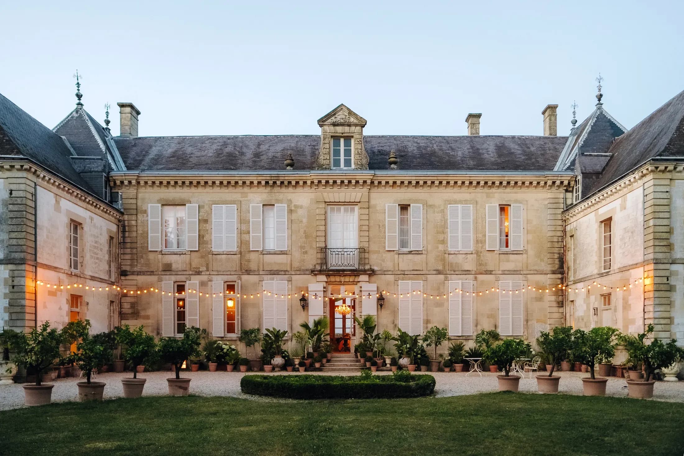 Beleuchtetes Château mit Garten in der Abenddämmerung