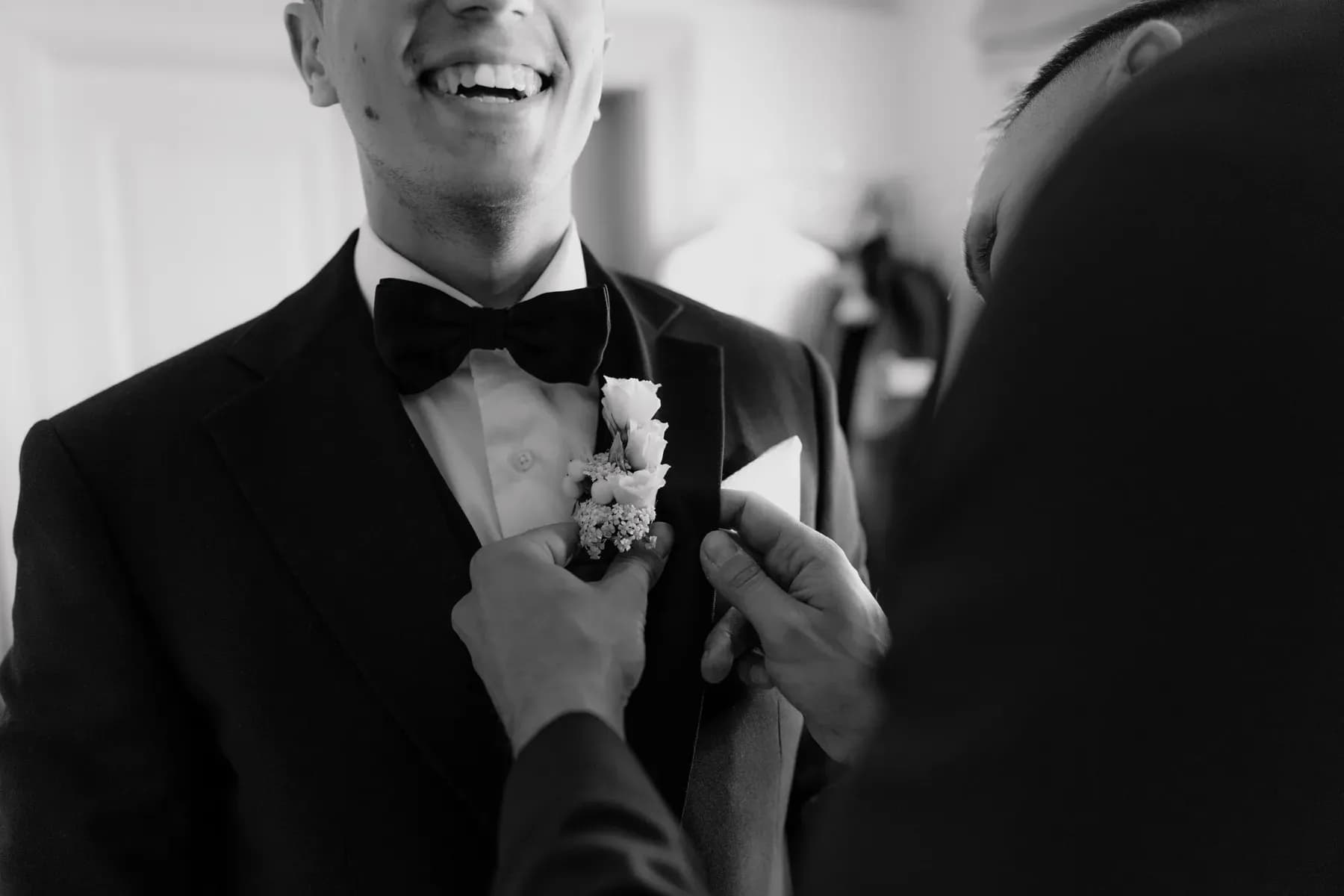 Der Bräutigam beim Anstecken seiner Boutonnière